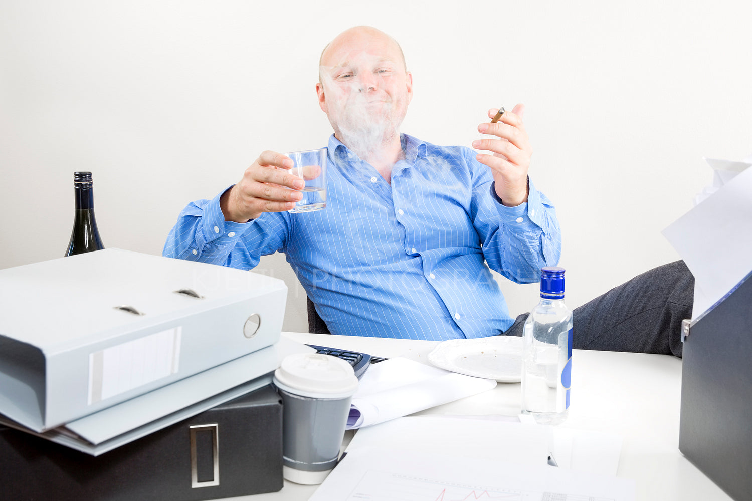 Drunk businessman smokes and drink at office