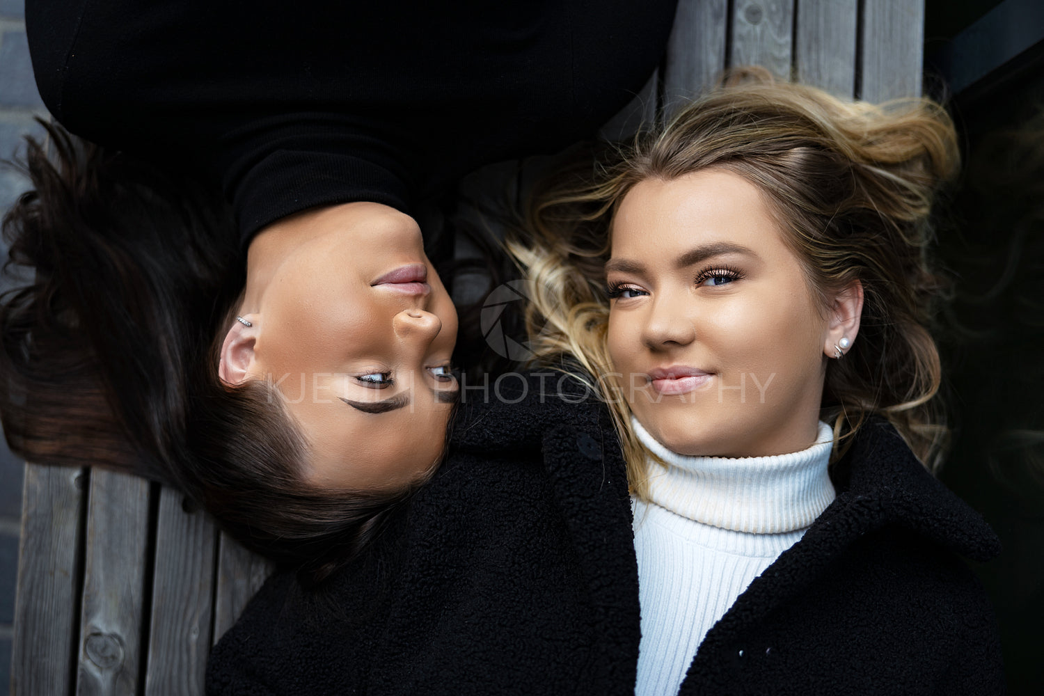 Close-up portrait Of Two Smiling Best Friends Lying On Bench