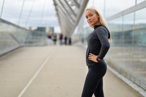 Sporty Woman in Black Workout Outfit Standing At Modern Bridge In City