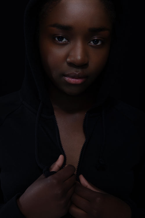 Cool and reticent woman with dark skin and attitude wearing hoodie