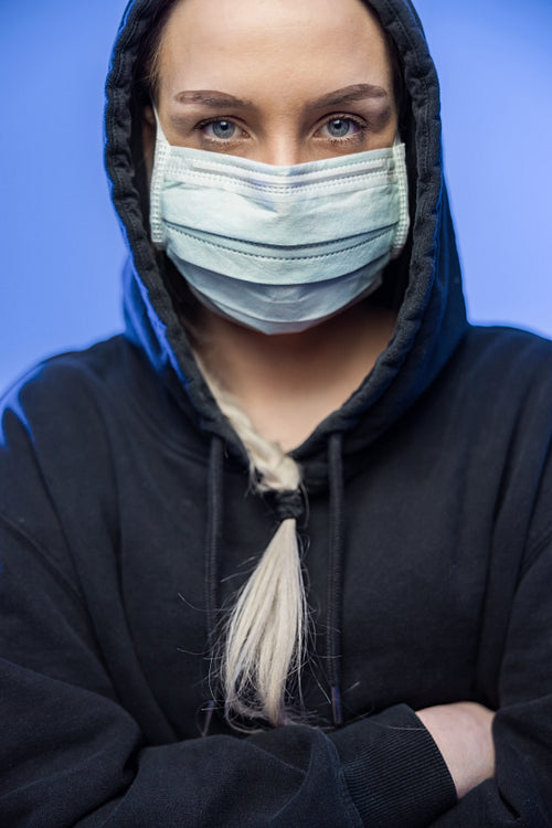 Cool caucasian woman in protective face mask with blue color lights