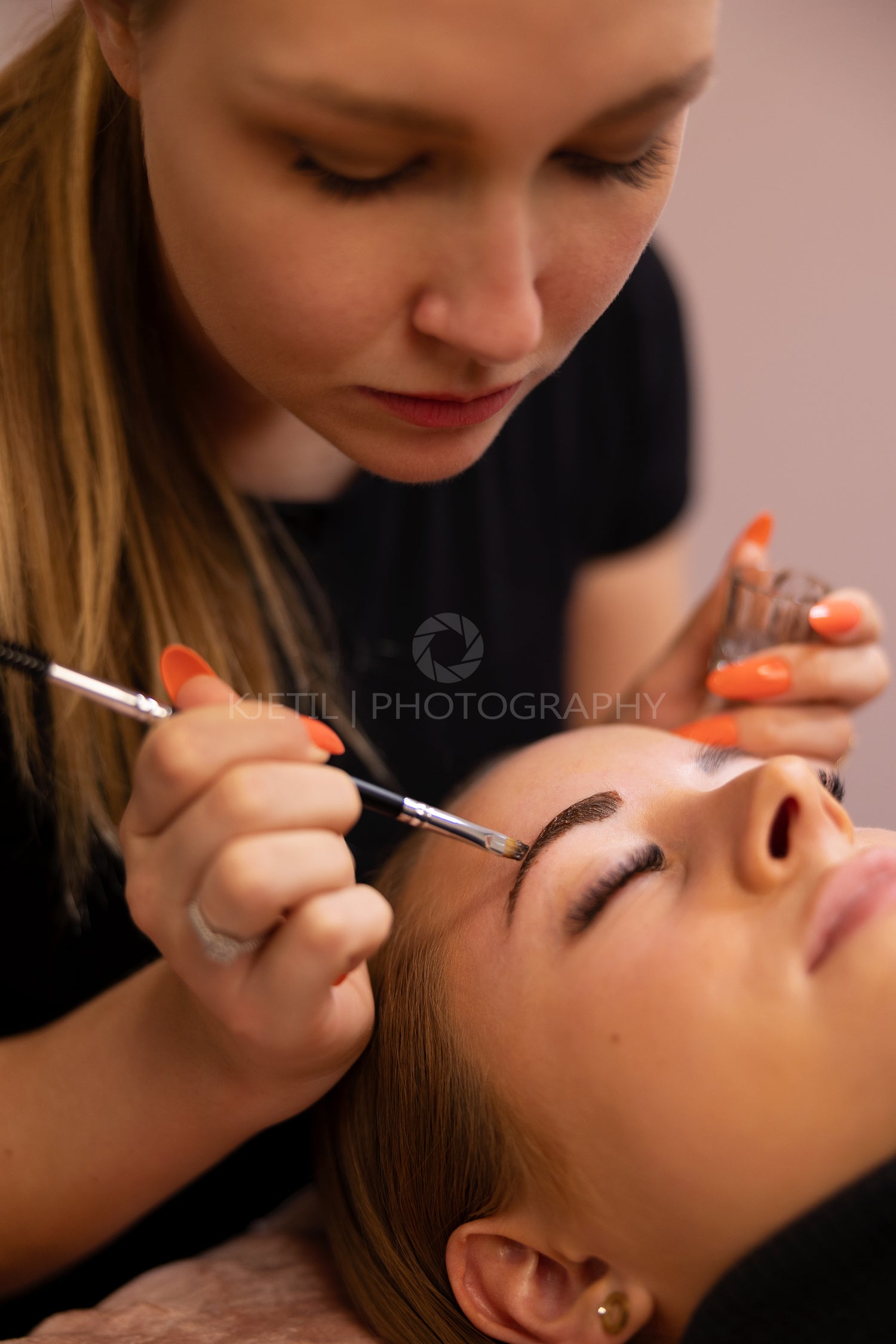 Cosmetologist Applying Dye On Female Client's Eyebrow