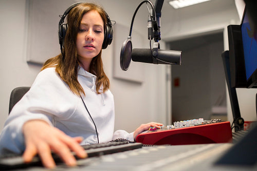 Focsued Radio Host Wearing Headphones In Studio