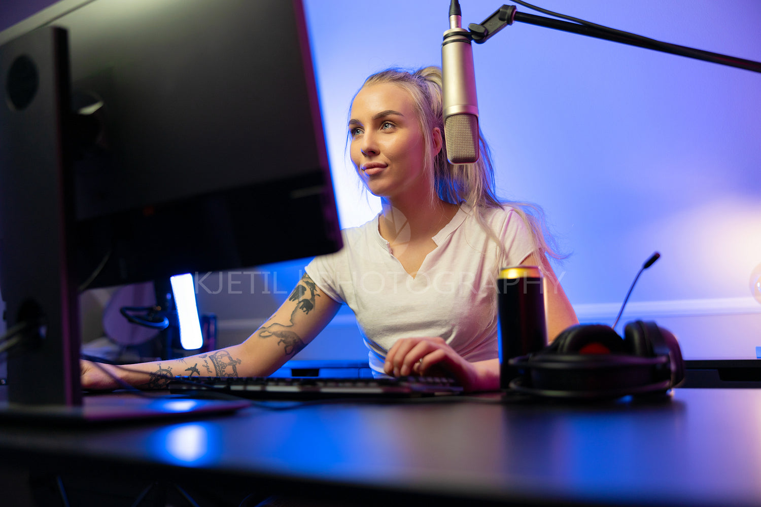 Cool looking professional gamer girl streams and play online multiplayer video game on PC