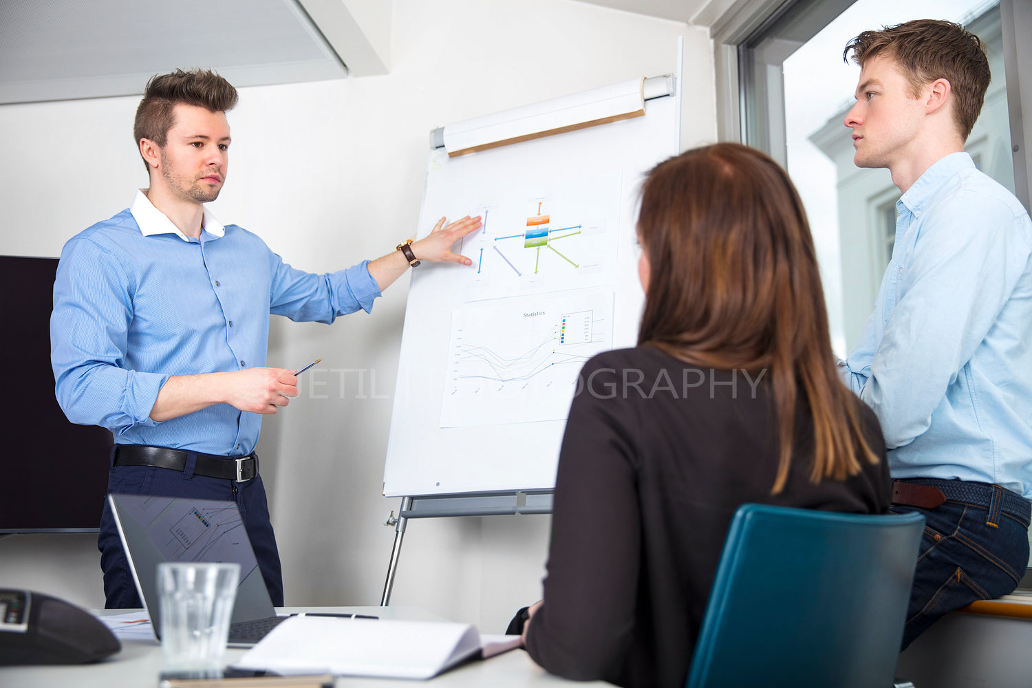 Businessman Explaining Chart To Male And Female Colleagues