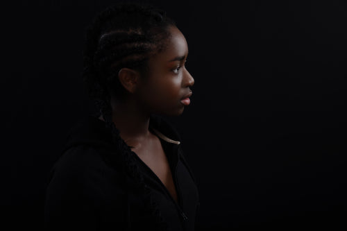 Natural and Beautiful Black Female Model Looking Away Against Black Background