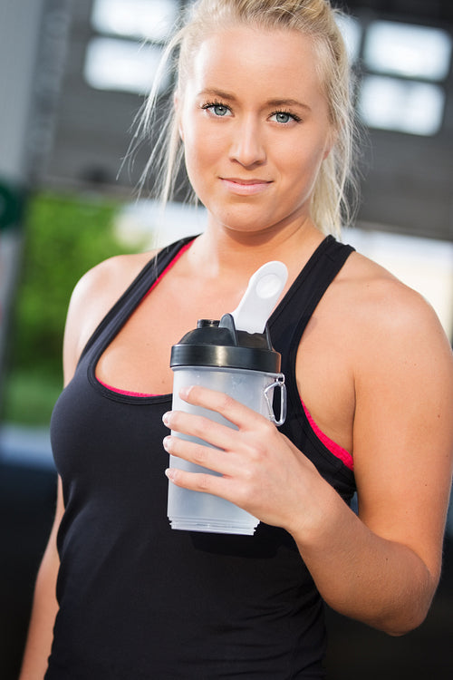 Portrait of woman rest and drinking water at fitness gym