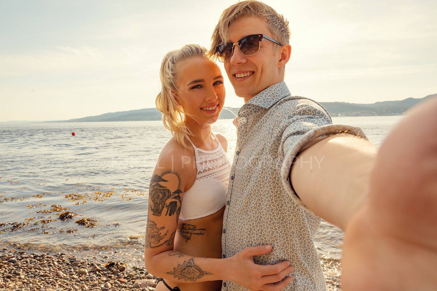 Smiling Young Man Taking Selfie With Girlfriend At Beach