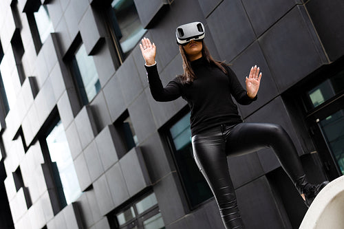 Dedicated Woman Wearing Virtual Reality Technology Glasses Against Building