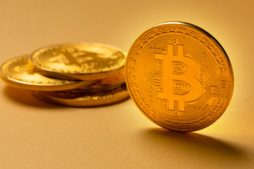 Gold bitcoin cryptocurrency coins on yellow backgound