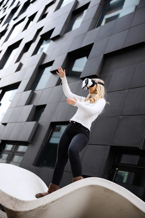 Young Woman Wearing Virtual Reality Glasses In Front Of Futuristic Building