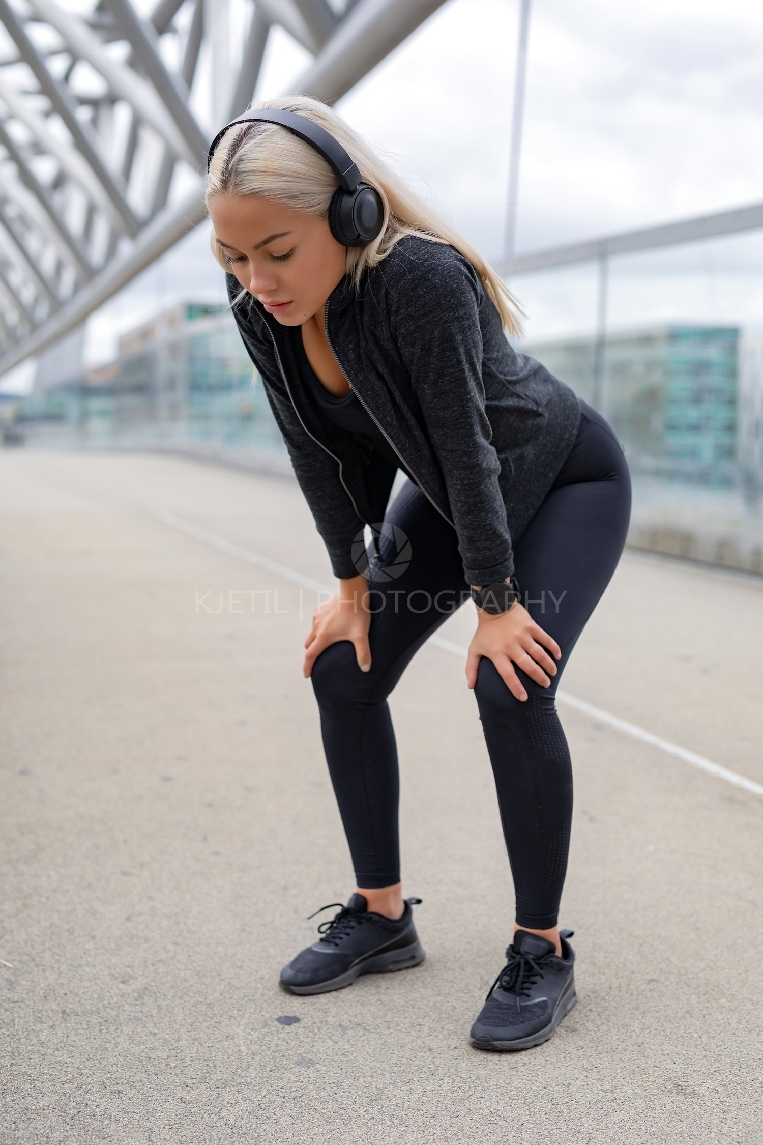 Tired Woman Resting With Hands On Knees After Running Workout