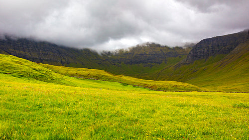 Green grass and mountains a cloudy day at Faroe Islands
