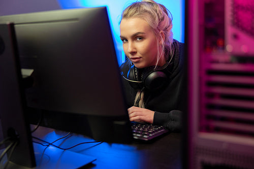 Professional E-sport Gamer Girl with Headset Playing Online Video Game on PC