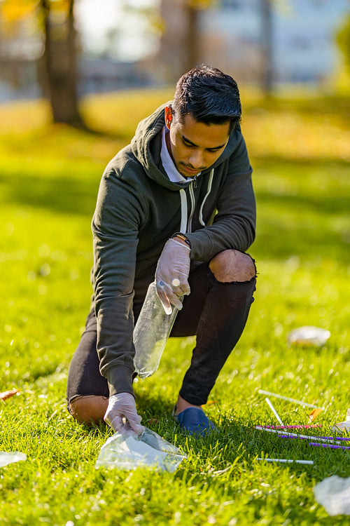 Volunteer cleaning garbage on grass at park