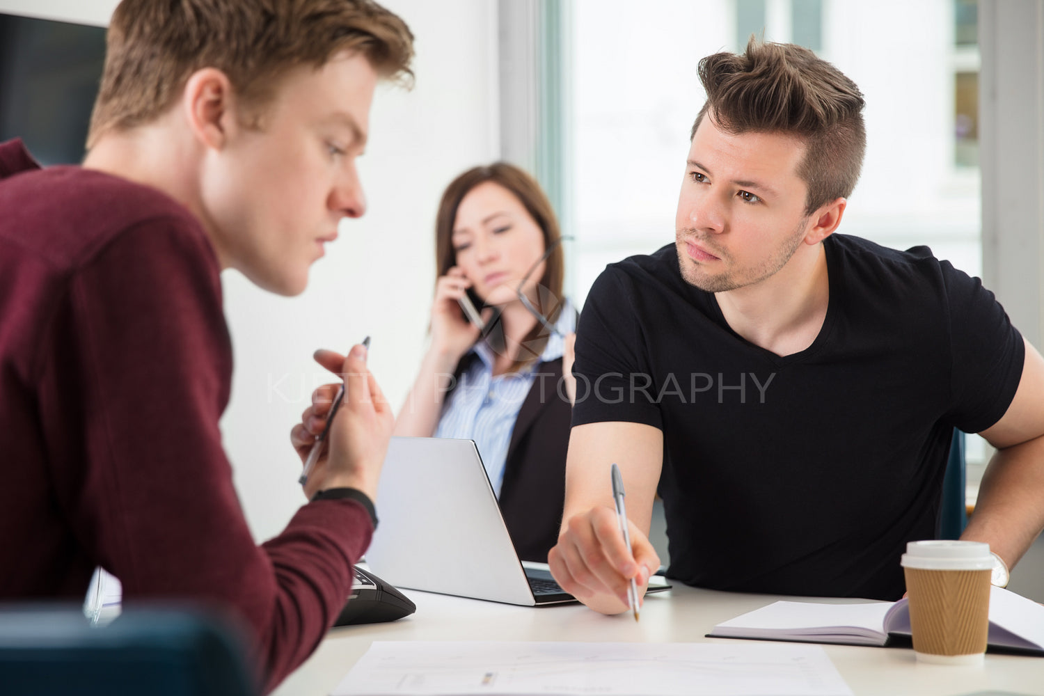 Professionals Planning While Colleague Using Mobile Phone In Off
