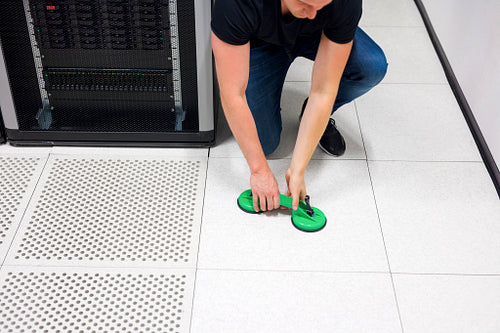 Engineer Lifting Floor Tile Using Vacuum Suction Cups In Datacen