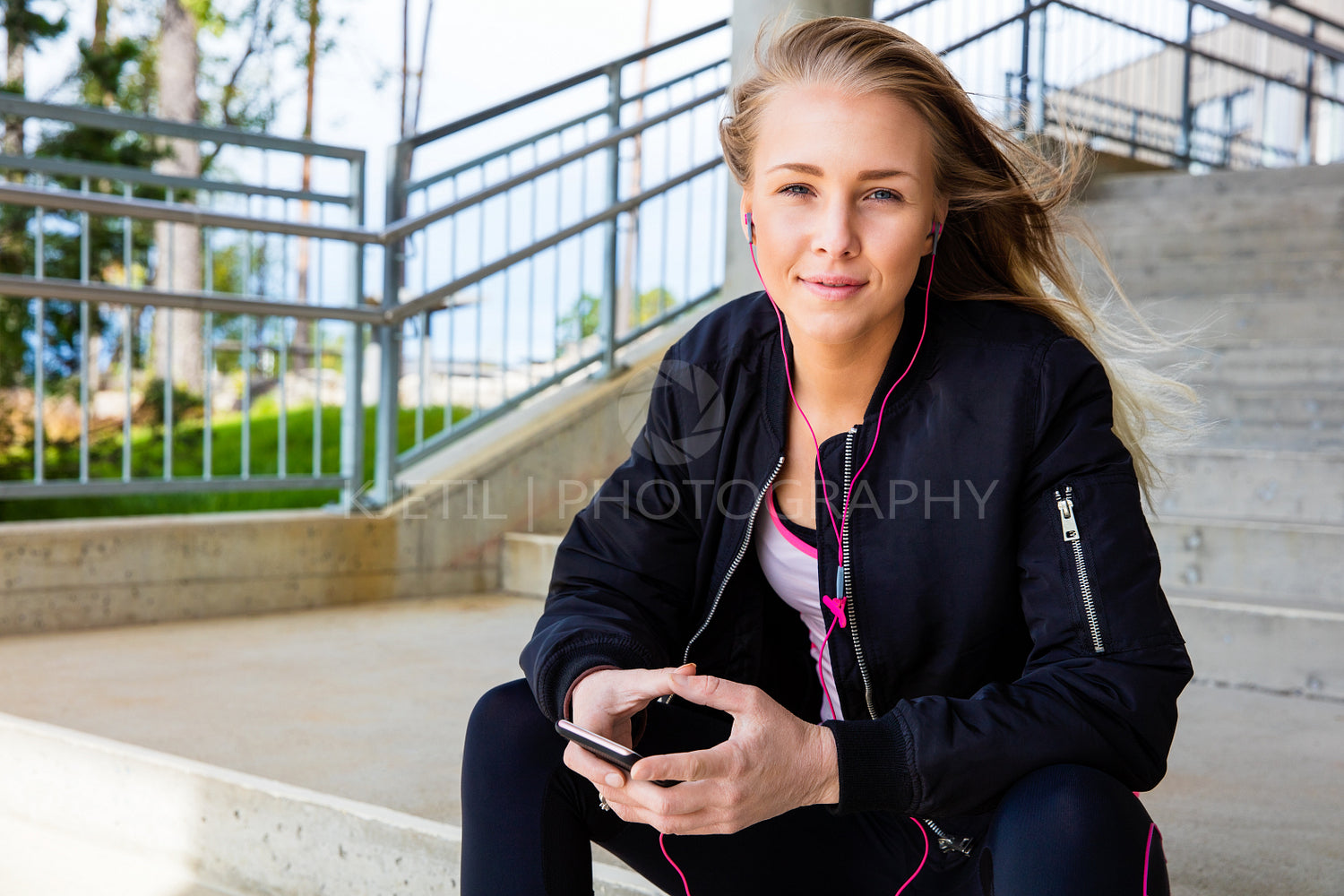 Young Woman In Sportswear Listening Music On Mobile Phone