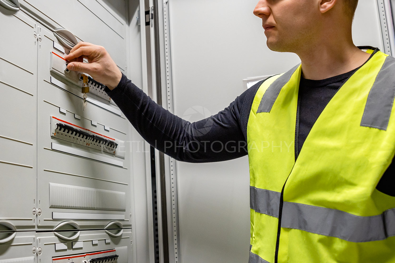 Male Electrician Checking Electric Fuse In Server Room