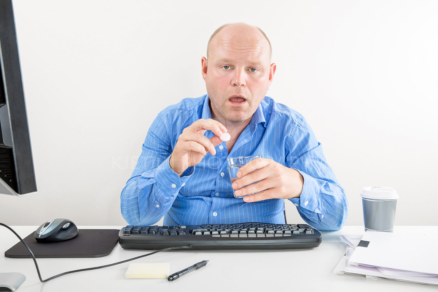Sick and overworked office worker taking pill