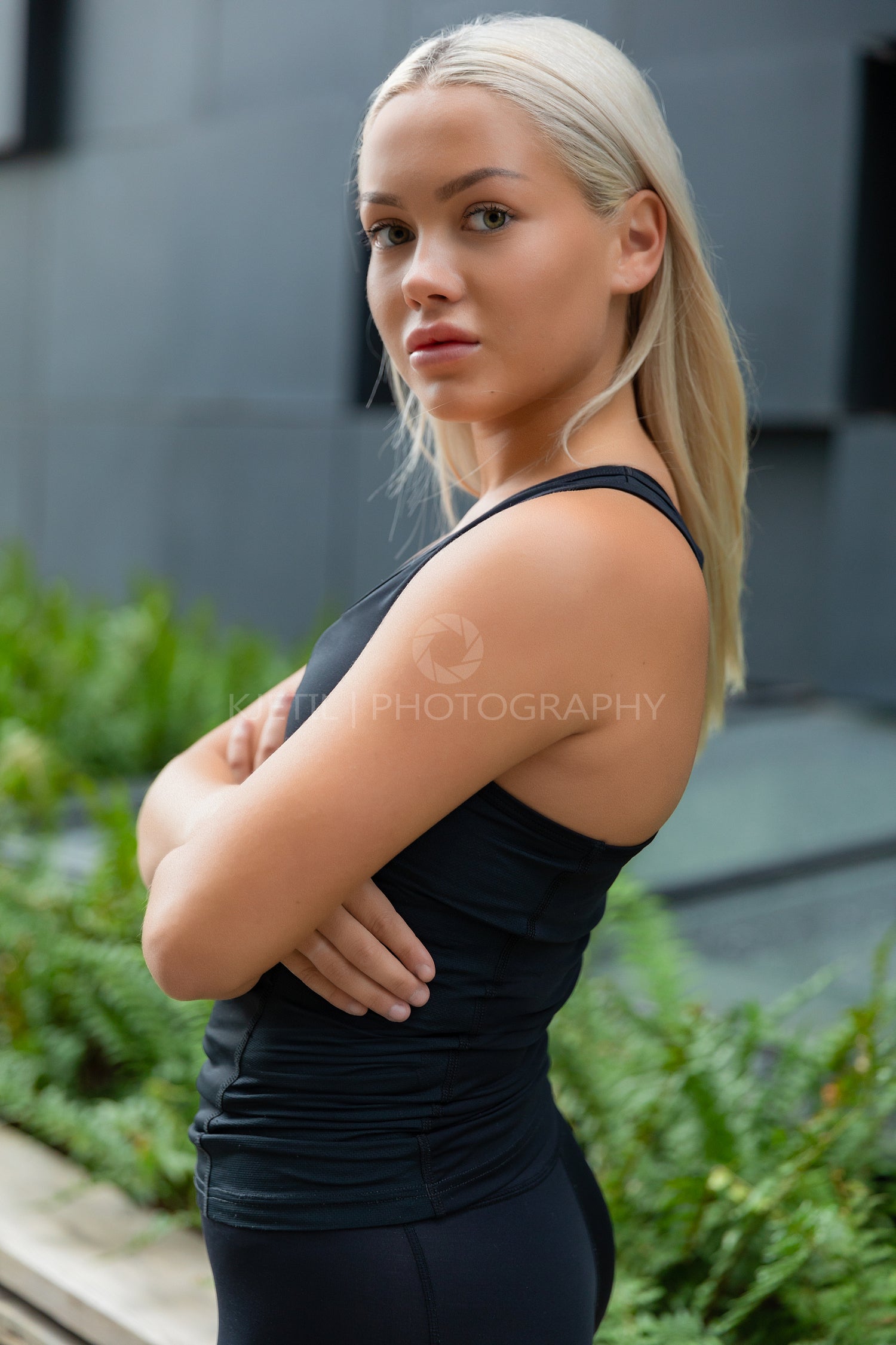 Portrait of a Young Athletic Woman Standing Against Building In City