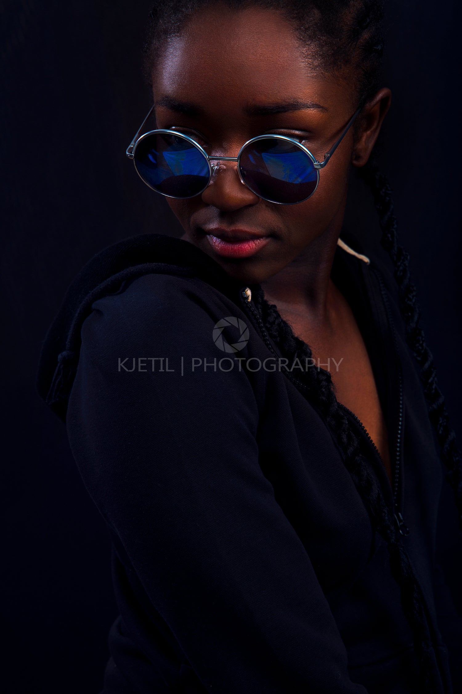 Cool young woman with dark skin wearing round sunglasses