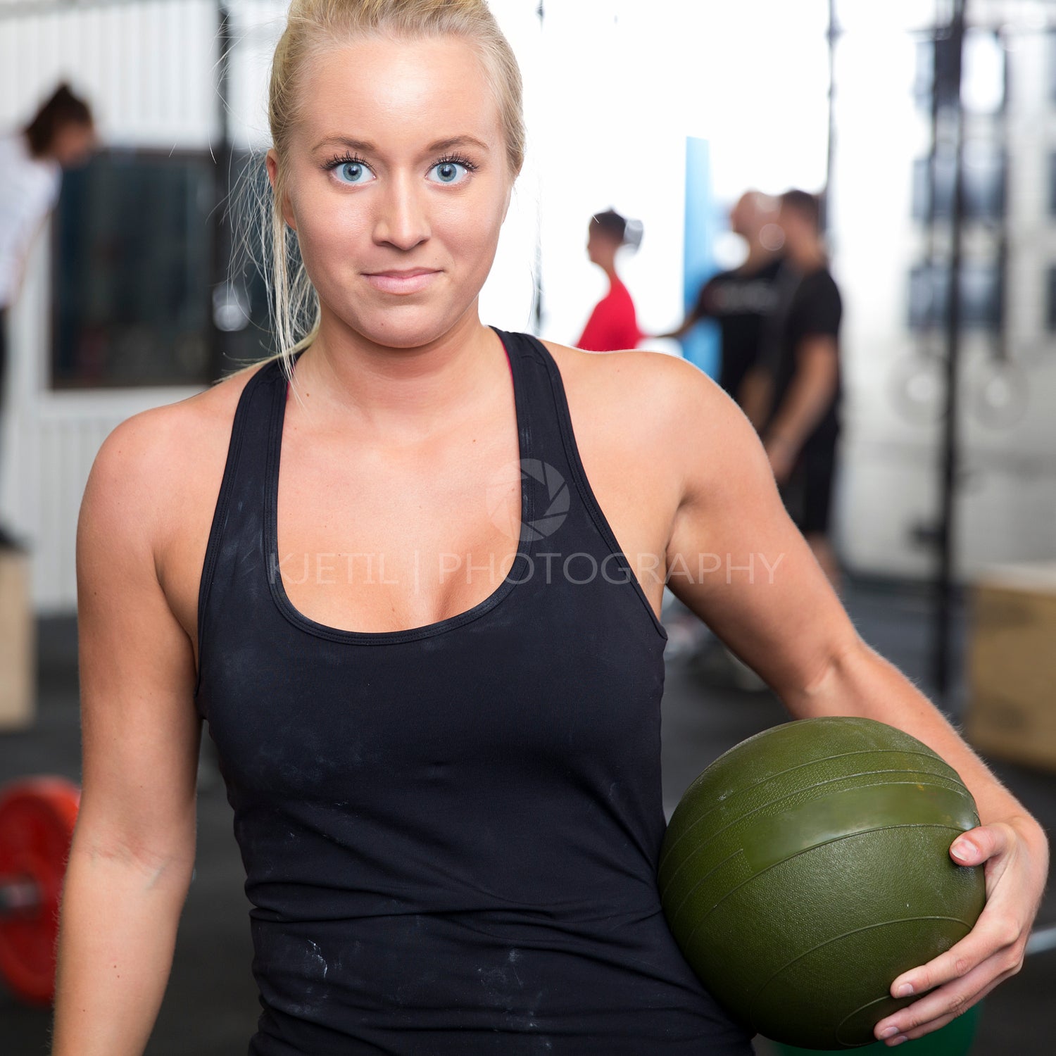 Smiling young woman with slam ball at gym center