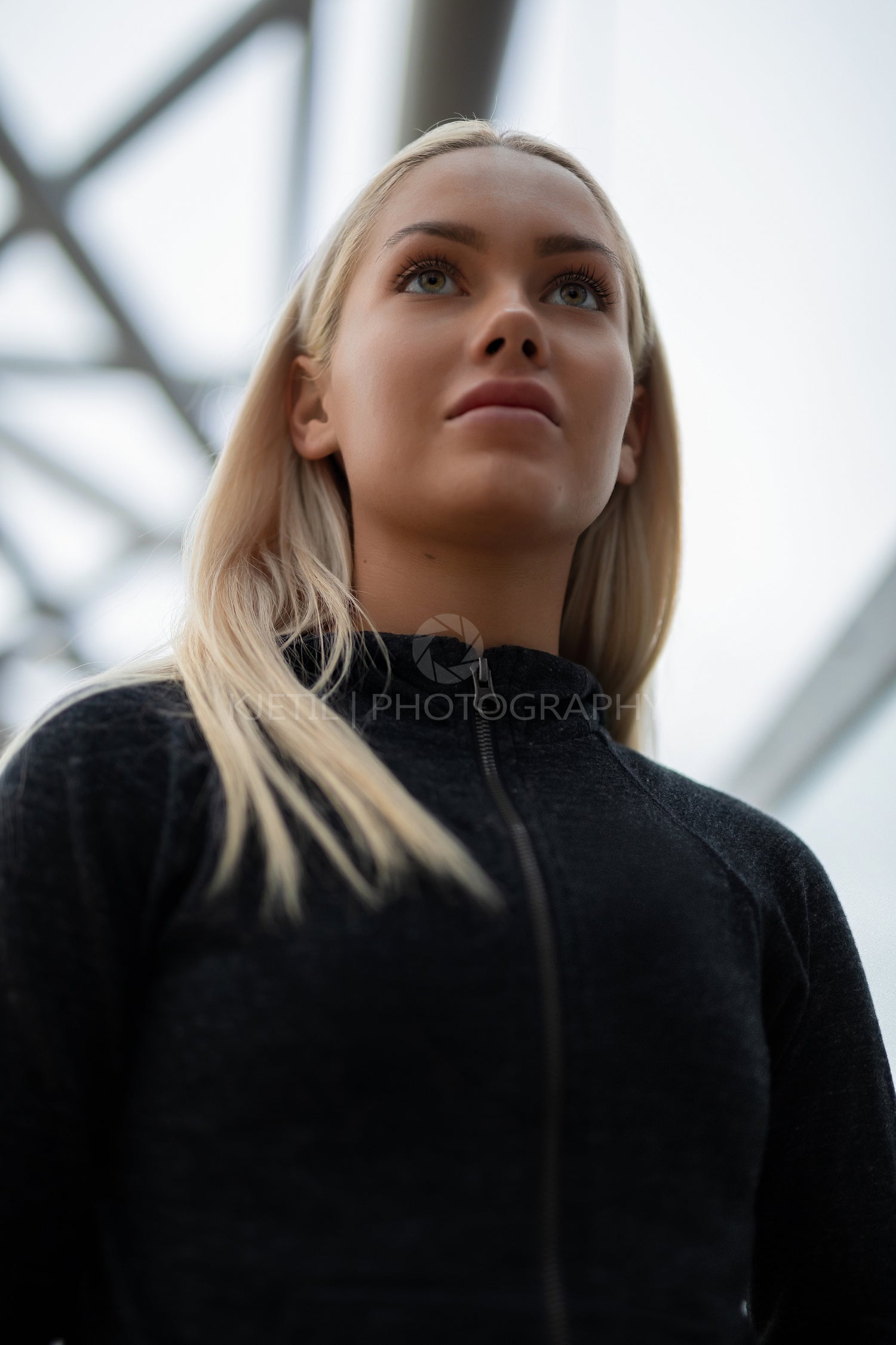 Urban scandinavian woman in workout outfit standing on a bridge
