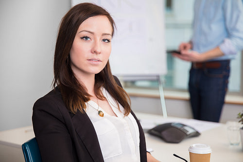 Confident Businesswoman Sitting At Desk In Office