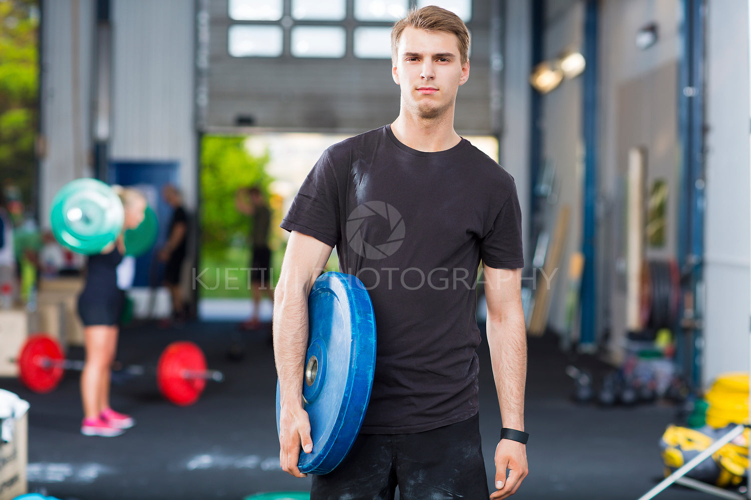 Determined Athlete Carrying Weight Plate In Health Club