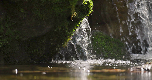 Slow motion of small waterfall stream at a water pond in the forest