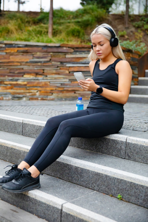 Sporty Young Woman Listening Music With Headphones And Smartphone