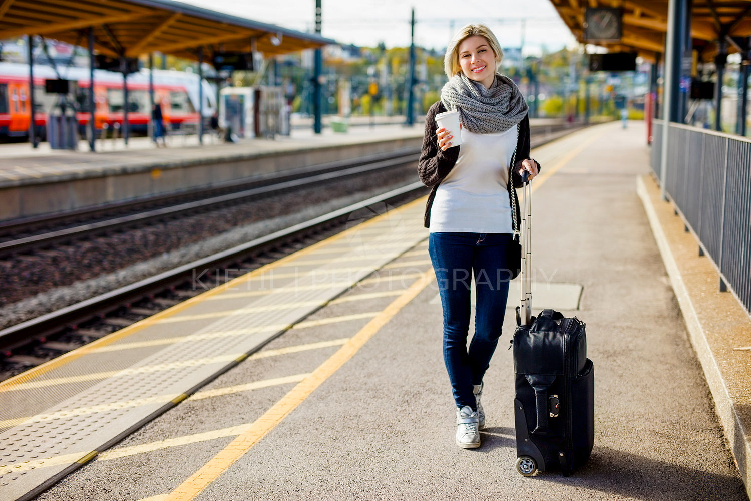 Woman With Luggage And Coffee Cup Waiting At Train Station