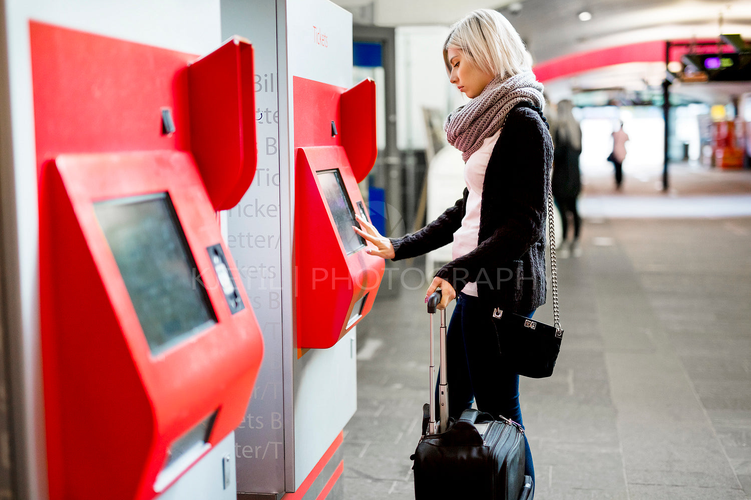 Woman Buying Train Ticket Using Vending Machine At Station