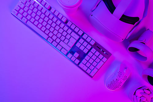 Keyboard with mouse and accessories on purple desk