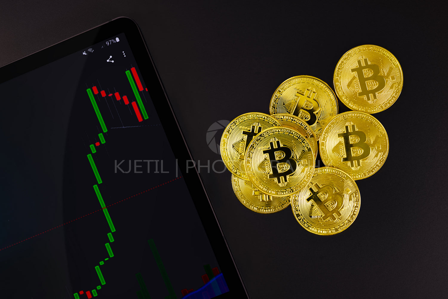 Bitcoin by digital tablet with bull exchange graph and crypto coins