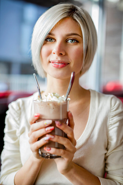 Woman Holding Glass Of Hot Chocolate With Cream In Cafe