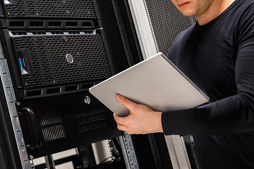 Close-up of IT Consultant Holding Digital Tablet Analyzing Servers