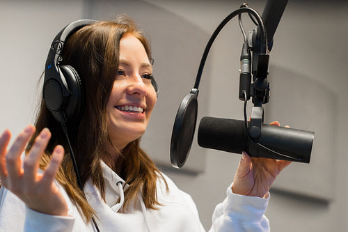 Close-up of a Female Jockey Communicating On Microphone In Radio Studio