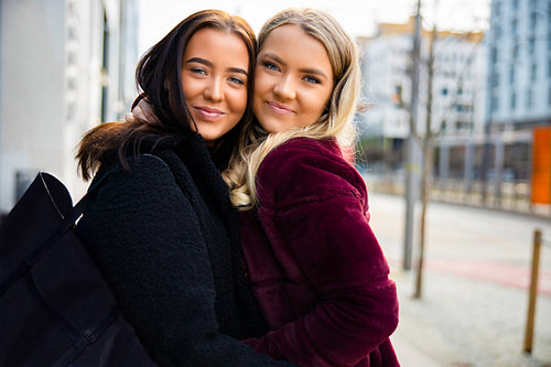 Portrait Of Smiling Friends Embracing In City