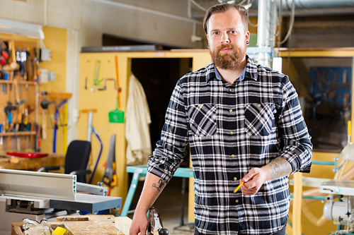 Environmental portrait of carpenter in a workshop