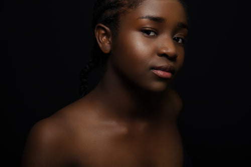 Confident and beautiful african woman with dark skin on black bakground