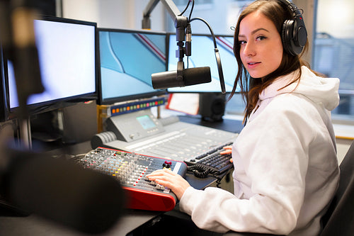 Portrait Of Jockey Using Headphones And Microphone In Radio Studio