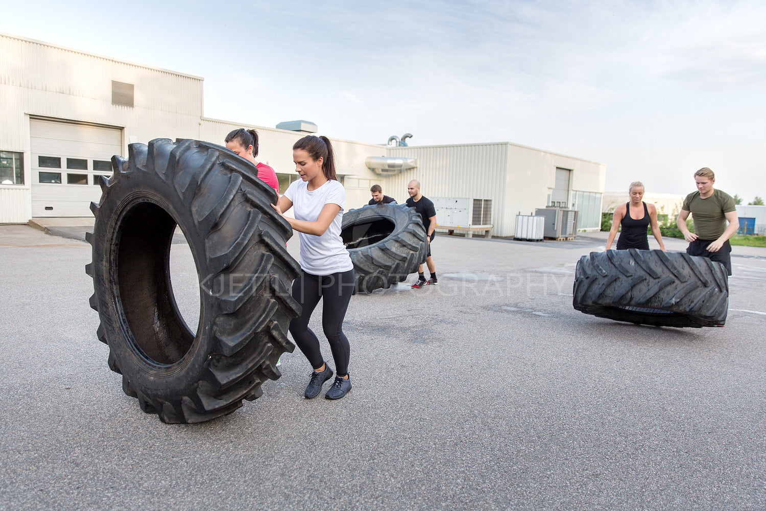 Fitness team flipping heavy tires as workout