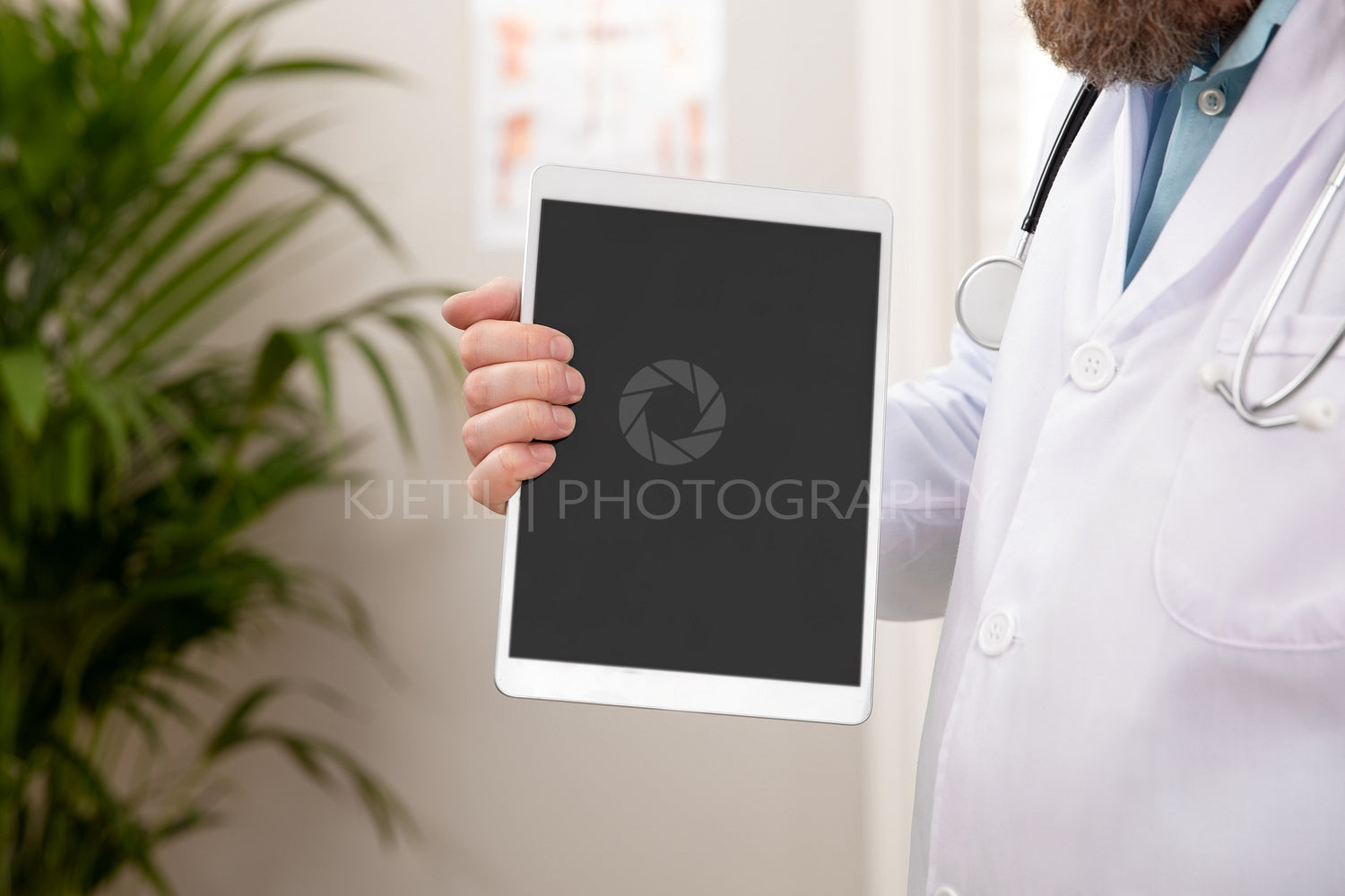 Adult male doctor showing a digital image or report on a tablet
