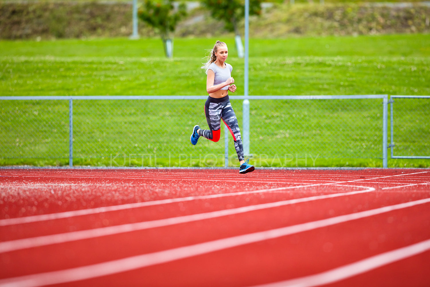 Determined Young Woman Running On Sports Tracks