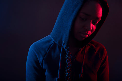 Colorful portrait of thoughtful woman with dark skin wearing hoodie