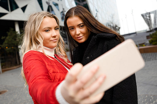 Friends Taking Selfie Through Smartphone In City