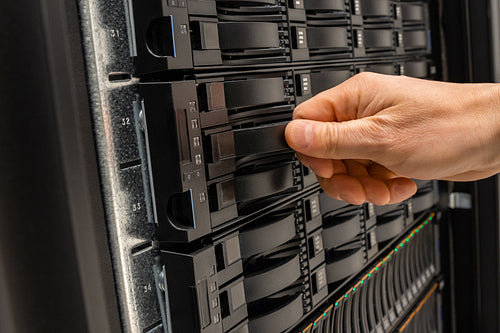 Male IT Engineer Replacing Server Drive in SAN At Datacenter