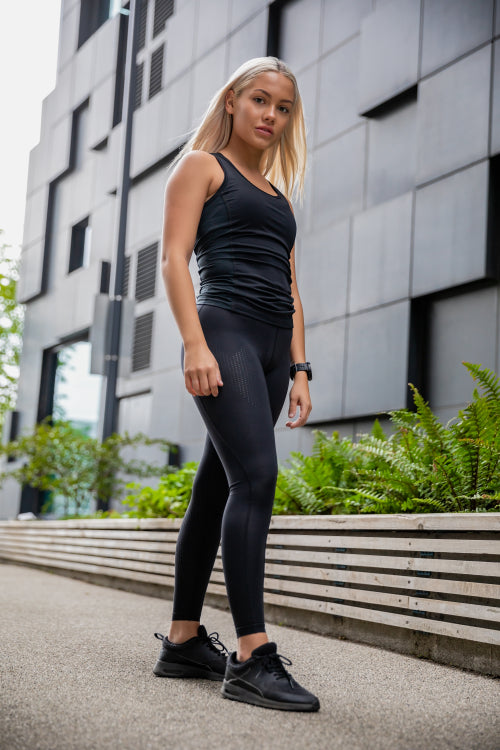 Young Athletic Woman Standing Against Building In City
